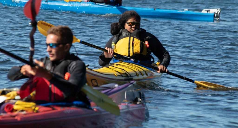 two outward bound students paddle their kayaks 